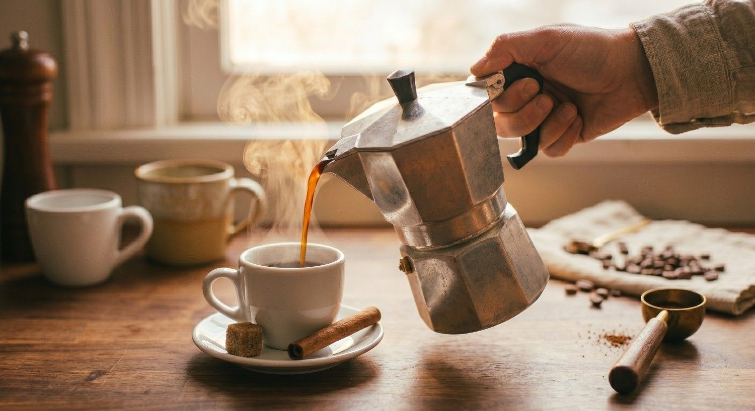 Café de italiana siendo vertido desde la moka hacia una taza